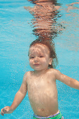 Image showing Happy toddler kid diving under water