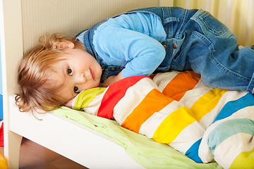 Image showing Tired toddler laying in his bed