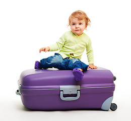 Image showing Kid sit on the big suitcase
