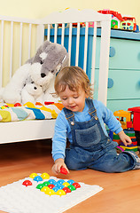 Image showing Smart little boy playing with mosaic