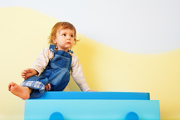 Image showing Happy kid sitting on the furniture