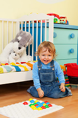 Image showing Laughing boy playing with mosaic