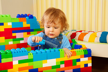 Image showing Little boy playing with plastic blocks