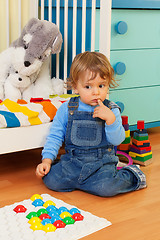 Image showing Puzzled boy playing with mosaic