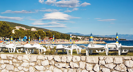 Image showing plastic sun loungers and umbrellas at beach