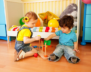 Image showing boy and girl playing with toy pyramid puzzle