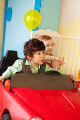 Image showing Boy and girl drive toy car
