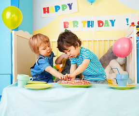 Image showing Two kids eating birthday cake