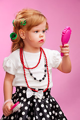 Image showing Little girl playing a hairdresser