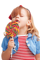 Image showing Little girl licking big lollipop