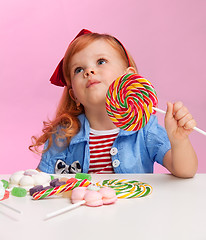 Image showing Thoughtful girl with lollipop