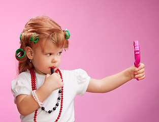 Image showing Little girl playing with mothers makeup