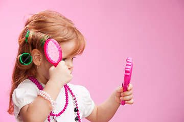 Image showing Little girl playing a hairdresser