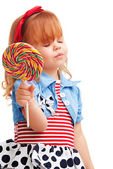 Image showing Happy girl smiling and holding lollipop, with closed eyes