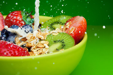 Image showing Adding milk to muesli with fruits breakfast