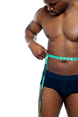 Image showing Muscular man measuring his waist