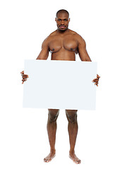 Image showing Naked man hiding behind blank white billboard