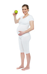 Image showing Pregnant woman showing fresh green apple