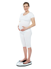 Image showing Pregnant woman measuring her weight