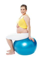 Image showing Relaxed pregnant woman sitting on pilate ball