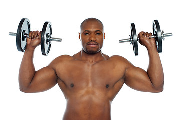 Image showing Shirtless african male holding dumbbells