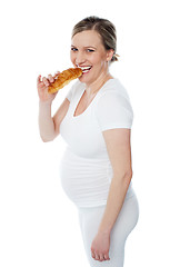 Image showing Pretty pregnant lady eating fast food