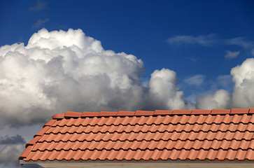 Image showing Roof tiles and blue sky with clouds