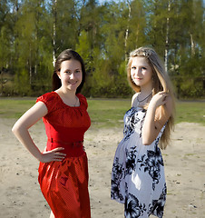 Image showing Two girls in dresses walk in the park