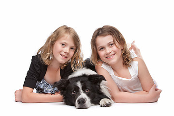 Image showing Two girls and a dog