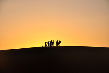 Image showing Silhouette of travelers at sunset