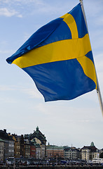 Image showing Swedish flag waving over the buildings of Stockholm old town