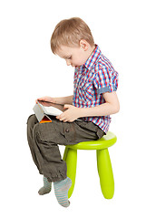 Image showing boy with a Tablet PC sitting on a green children's chair