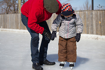 Image showing Father teaching son how to ice skate