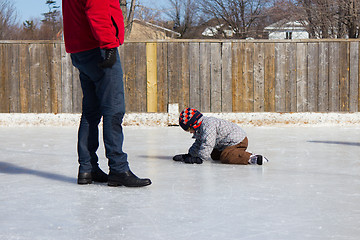 Image showing Father teaching son how to ice skate