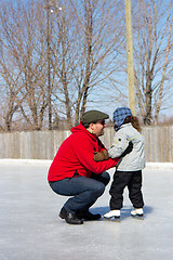 Image showing Father teaching daughter how to ice skate