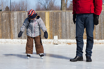Image showing Father teaching son how to ice skate