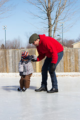 Image showing Father teaching son how to ice skate