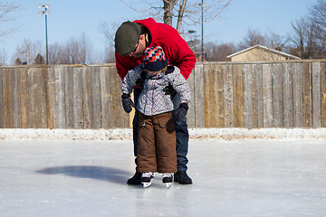 Image showing Father teaching son how to ice skate