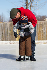 Image showing Father teaching son how to ice skate