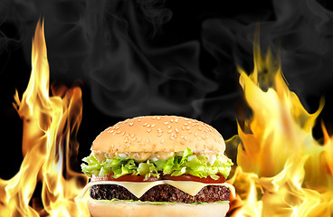 Image showing Hamburger with fire on black background