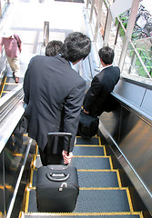 Image showing Businessmen on moving staircase