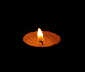 Image showing A single burning yellow candle