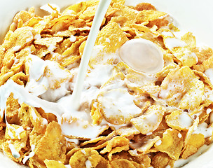 Image showing milk stream flowing to the bowl with corn flakes