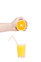 Image showing hand pour orange juice from orange