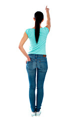 Image showing Rear view of young woman in casuals, pointing