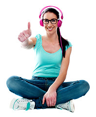 Image showing Thumbs-up woman enjoying music