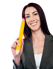 Image showing Thoughtful businesswoman holding big pencil