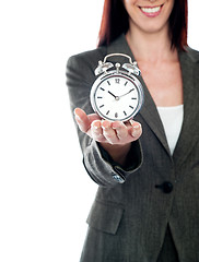 Image showing Cropped image of a woman holding alarm clock