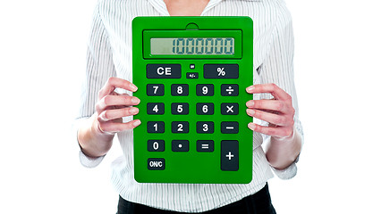 Image showing Focus on green calculator. Woman holding