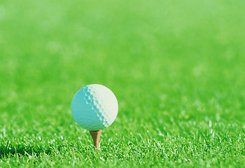 Image showing Golf ball on tee over a blurred green.